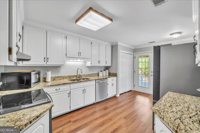 a kitchen with granite countertop a stove a sink and a refrigerator
