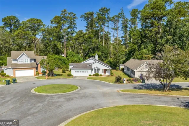 an aerial view of a house with swimming pool and large trees