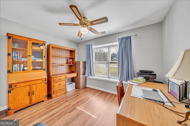a view of a workspace with furniture and wooden floor
