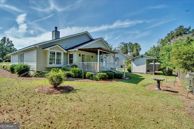 a view of house with outdoor space and garden