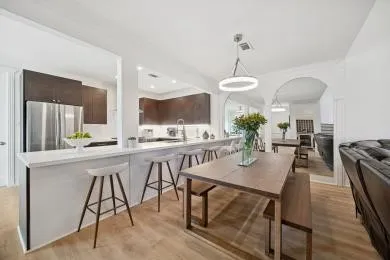 a dining room filled chandelier and kitchen view
