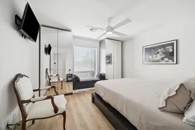 a bedroom with a bed a couch and a flat screen tv