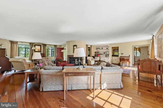 a living room with fireplace furniture and wooden floor