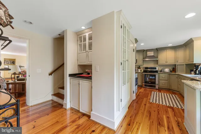 a kitchen with stainless steel appliances a refrigerator and wooden floor