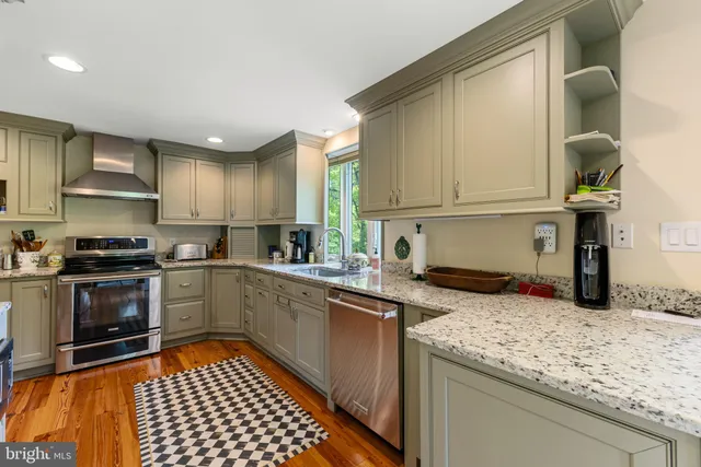 a kitchen with granite countertop a sink and stainless steel appliances