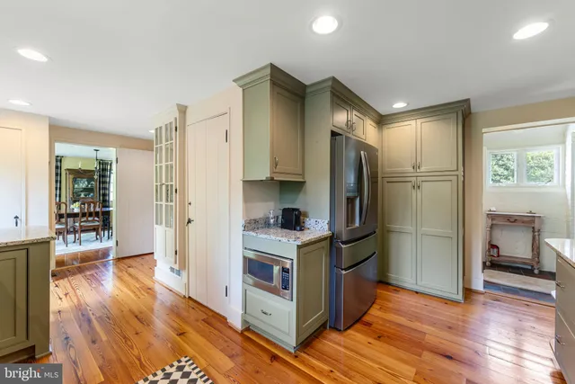 a kitchen with a refrigerator and wooden floor