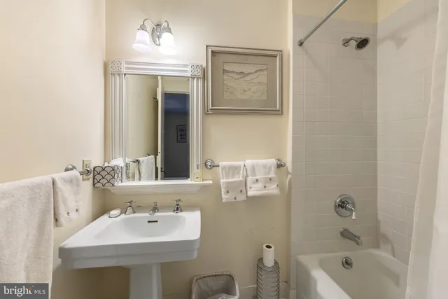 a bathroom with a sink tub shower and a mirror