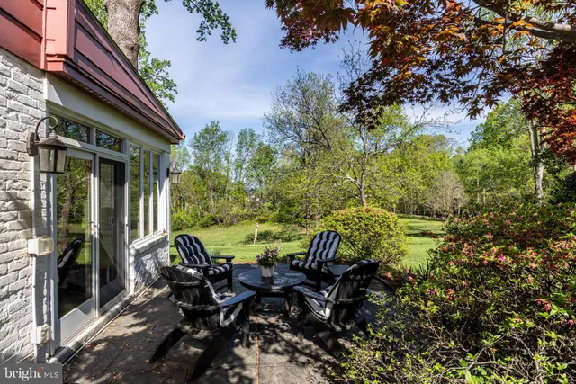 a view of a patio with table and chairs and floor to ceiling window
