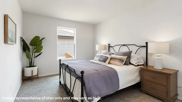 a bedroom with a bed and a potted plant