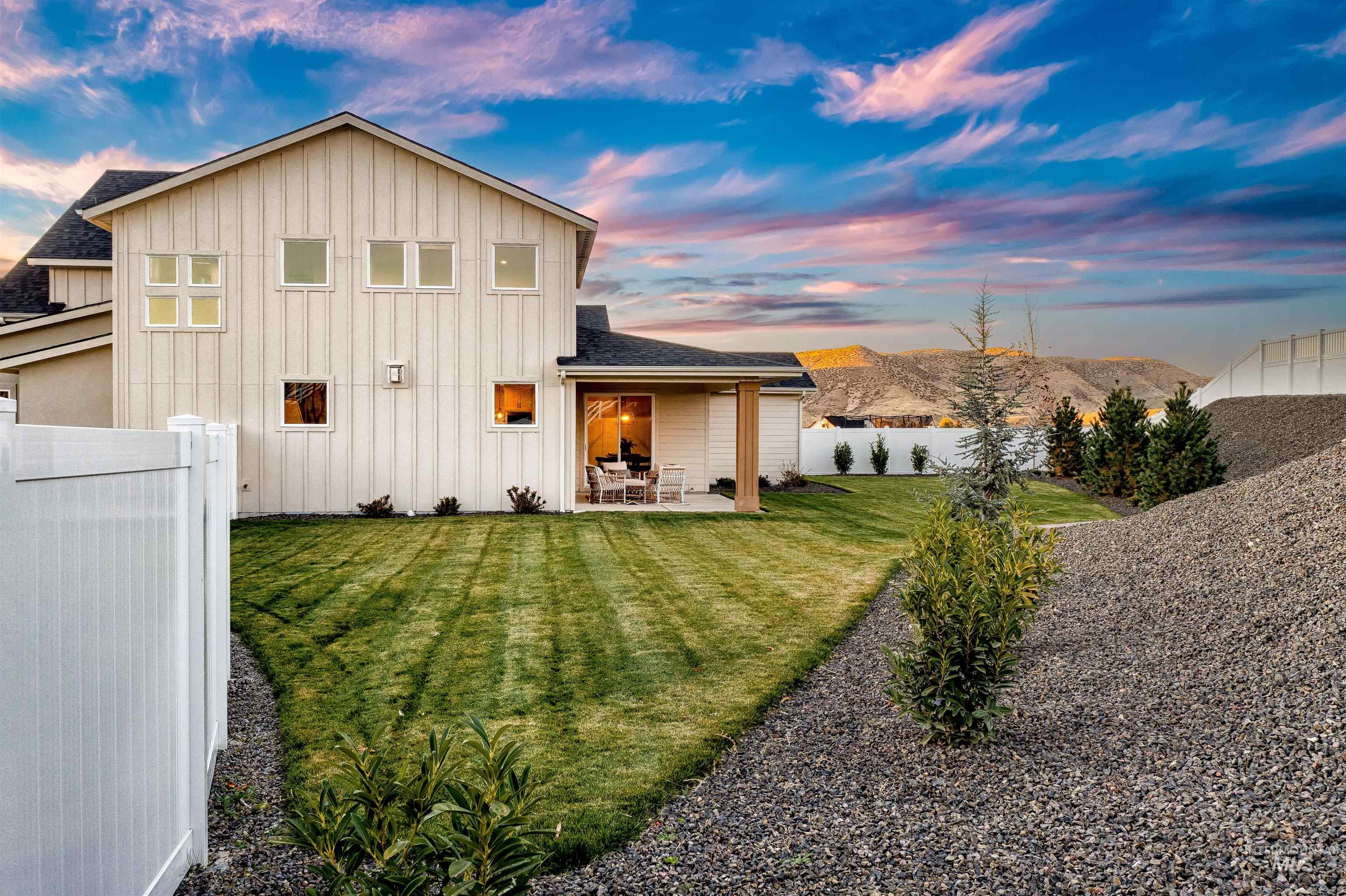 13544 North Ruffed Grouse Place Boise, ID 83714 - Photo 27 of 42 Back of house featuring a patio area, board and batten siding, a fenced backyard, and roof with shingles