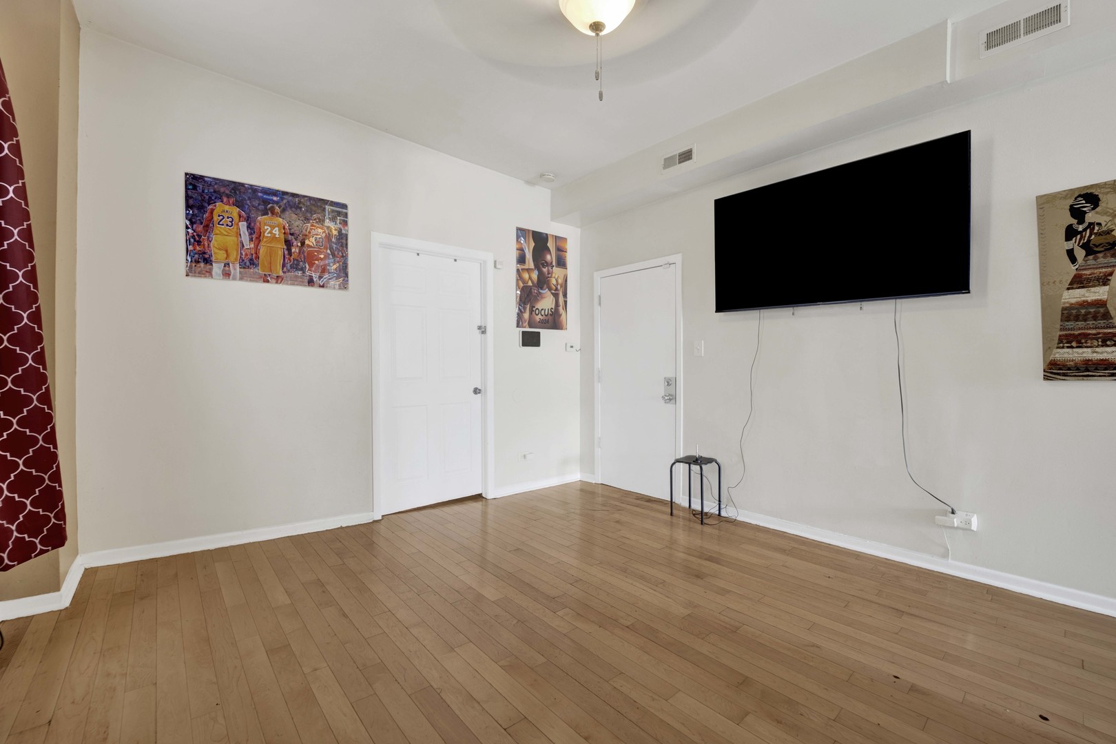 3326 West Crystal Street Chicago, IL 60651 - Photo 3 of 16 a view of an empty room with wooden floor and a flat screen tv