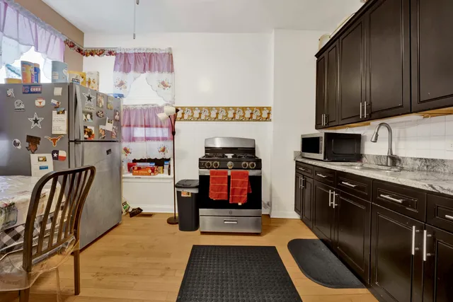 a kitchen with stainless steel appliances granite countertop a stove a sink and a microwave