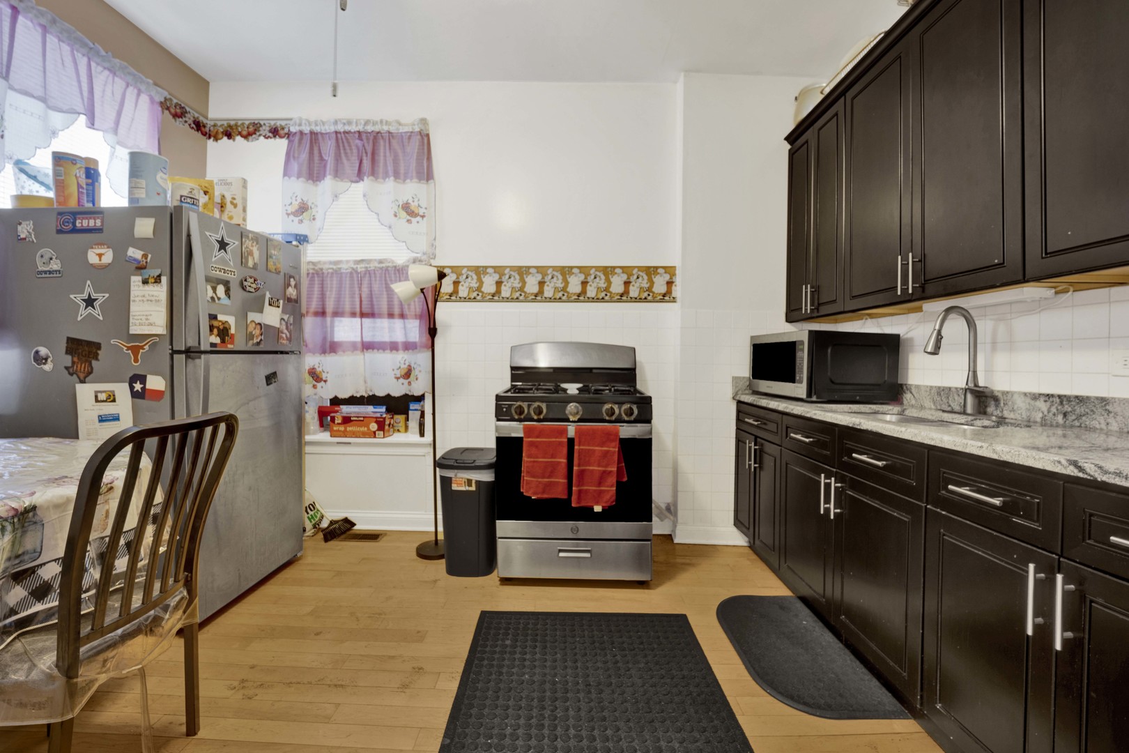 3326 West Crystal Street Chicago, IL 60651 - Photo 7 of 16 a kitchen with stainless steel appliances granite countertop a stove a sink and a microwave