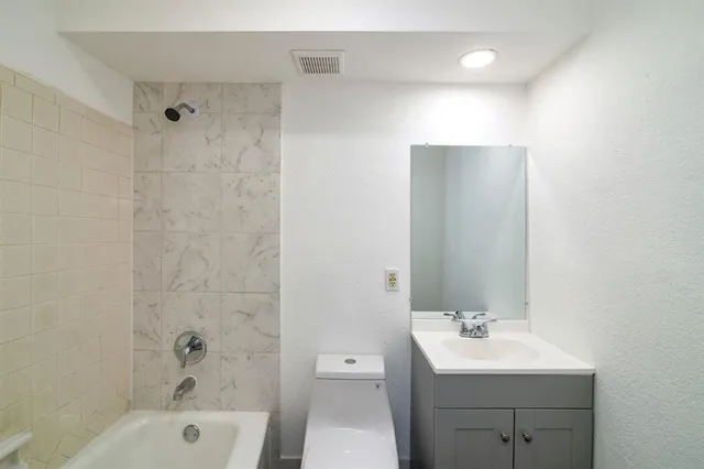 a bathroom with a toilet a sink a mirror and shower