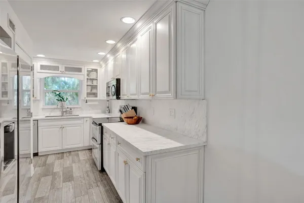 a kitchen with stainless steel appliances white cabinets and a sink