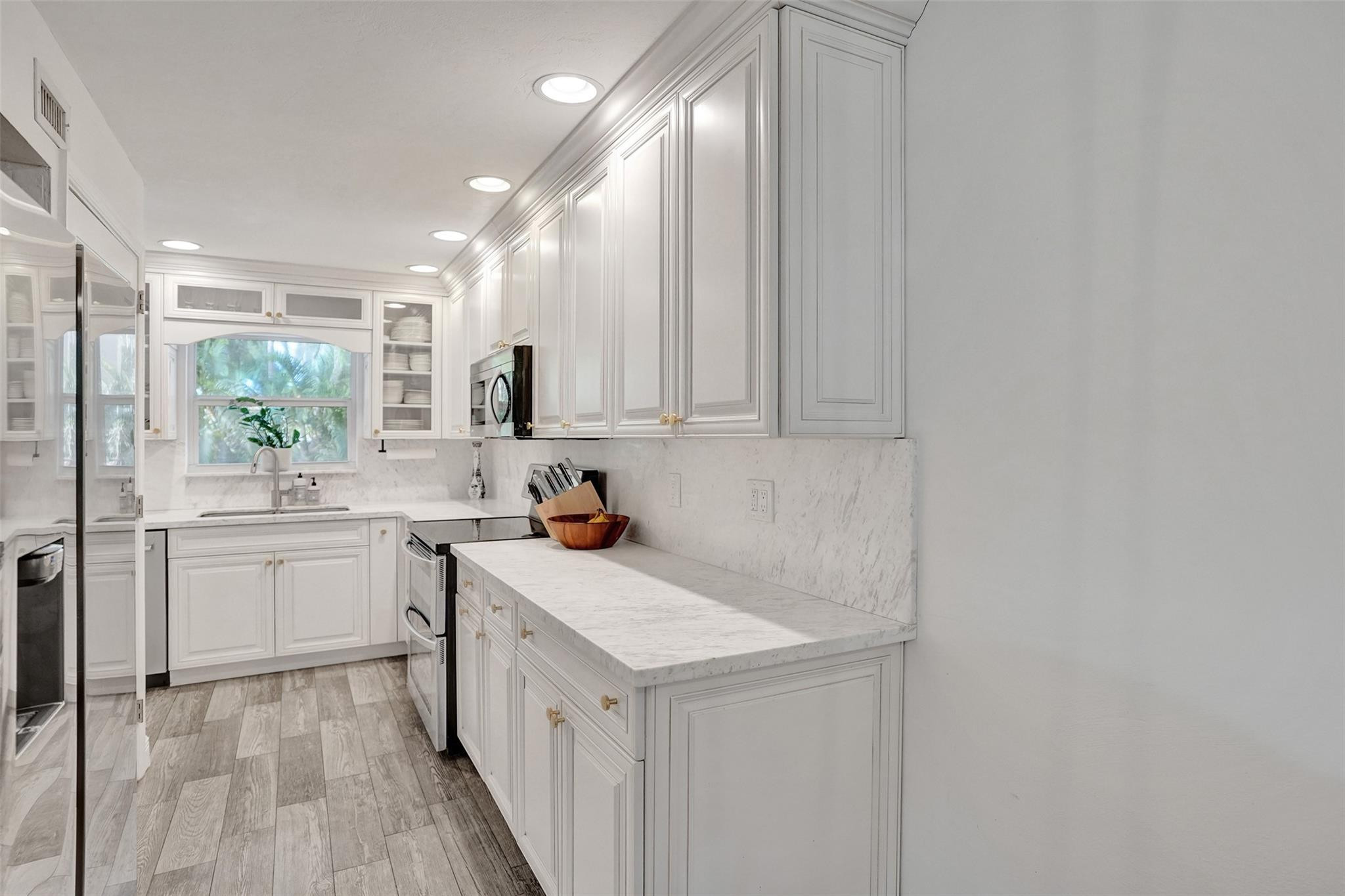 2501 South Ocean Boulevard, Unit 103 Boca Raton, FL 33432 - Photo 12 of 49 a kitchen with a sink stove and cabinets