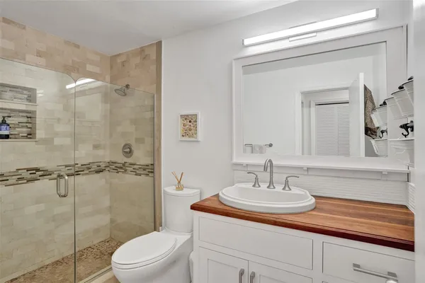 a white toilet next to a bathroom