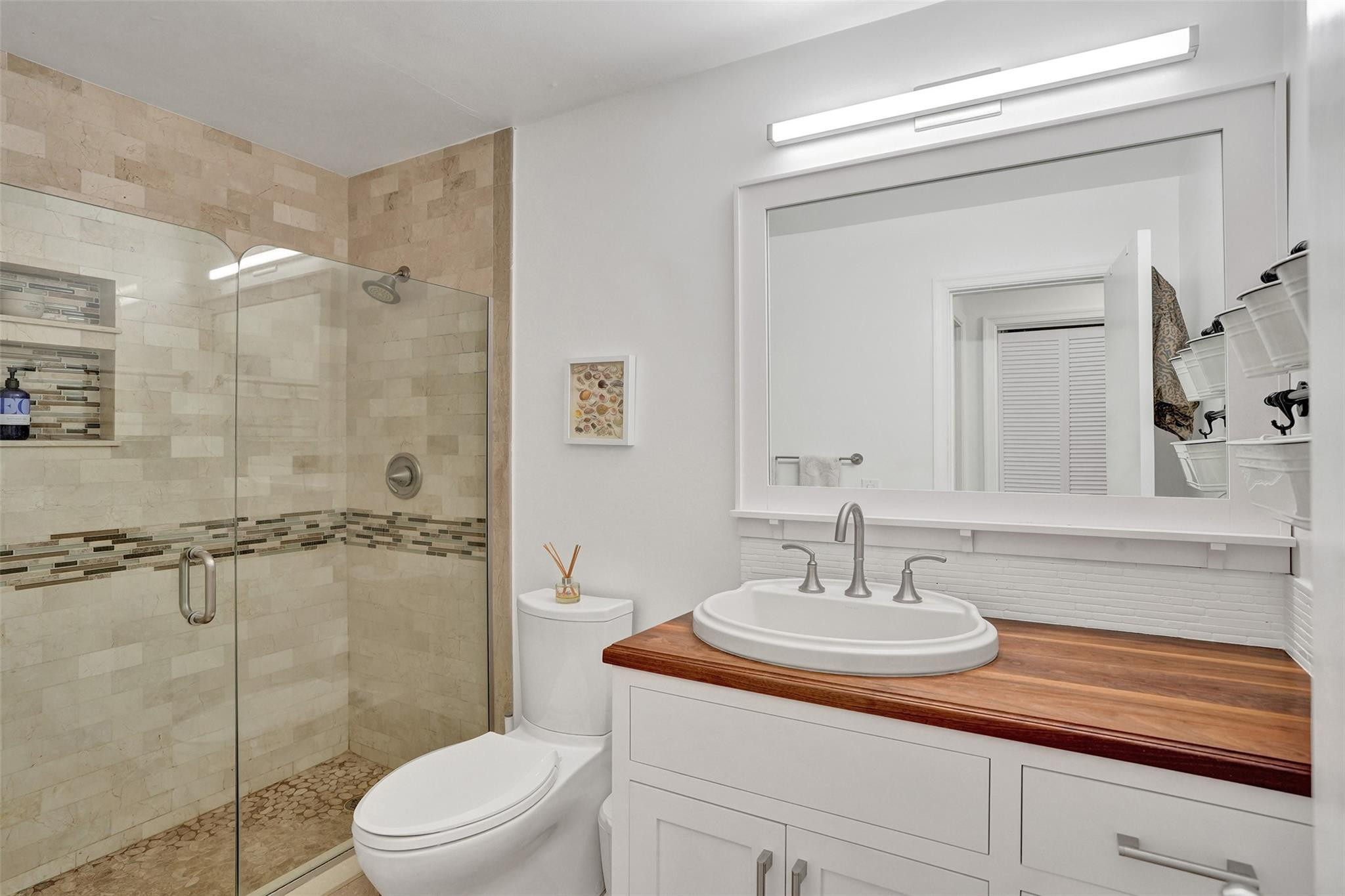 2501 South Ocean Boulevard, Unit 103 Boca Raton, FL 33432 - Photo 18 of 49 a bathroom with a sink a toilet and shower