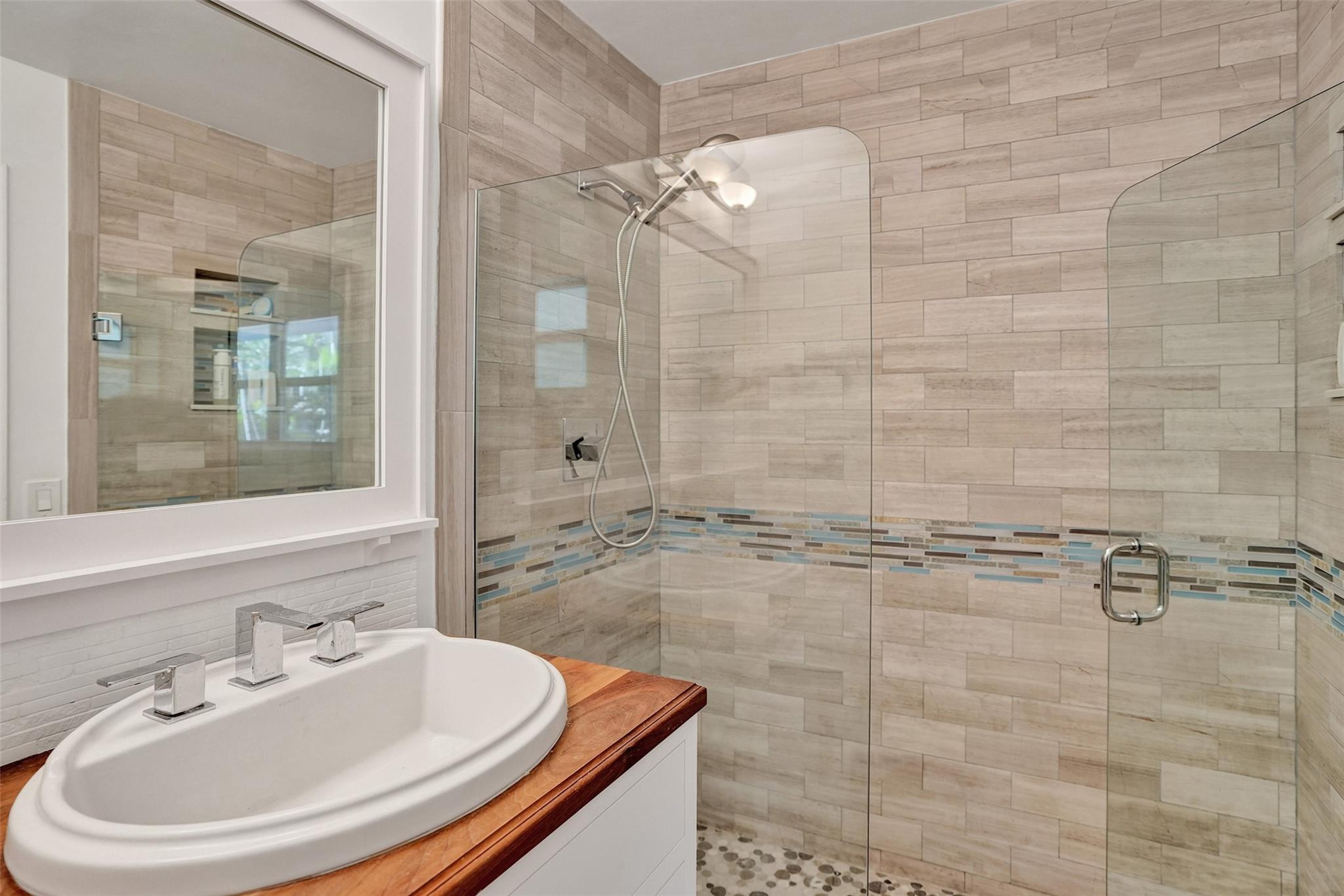 2501 South Ocean Boulevard, Unit 103 Boca Raton, FL 33432 - Photo 25 of 49 a bathroom with a sink a mirror and a shower
