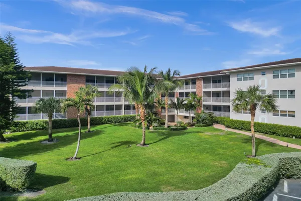 a view of a big building with a big yard and large trees