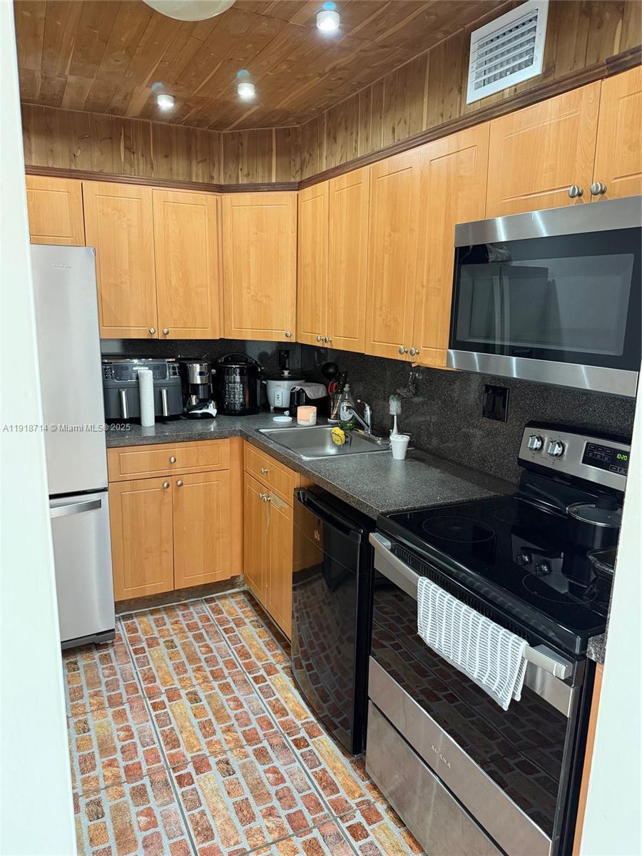 8411 Northwest 8th Street, Unit 405 Miami, FL 33126 - Photo 11 of 23 a kitchen with a sink a stove and refrigerator