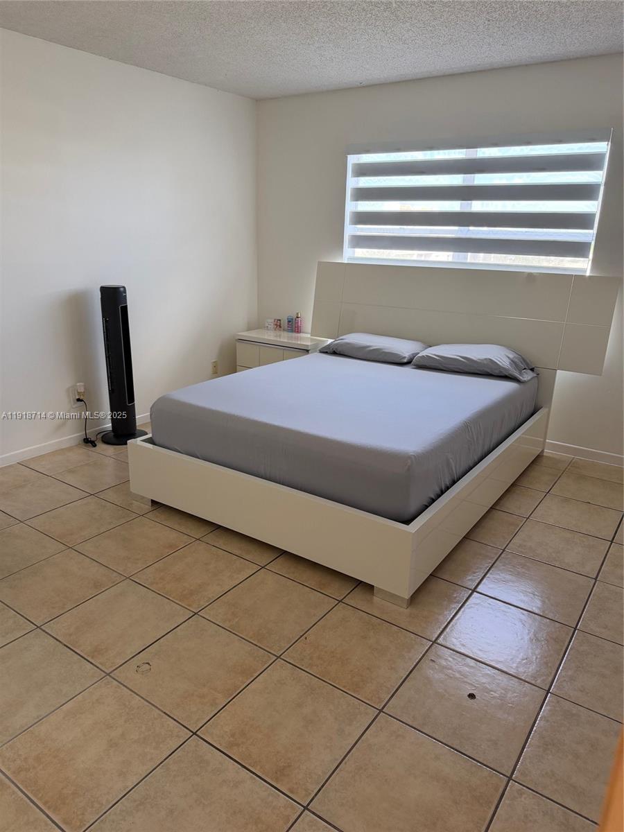 8411 Northwest 8th Street, Unit 405 Miami, FL 33126 - Photo 12 of 23 a bedroom with a bed and a window