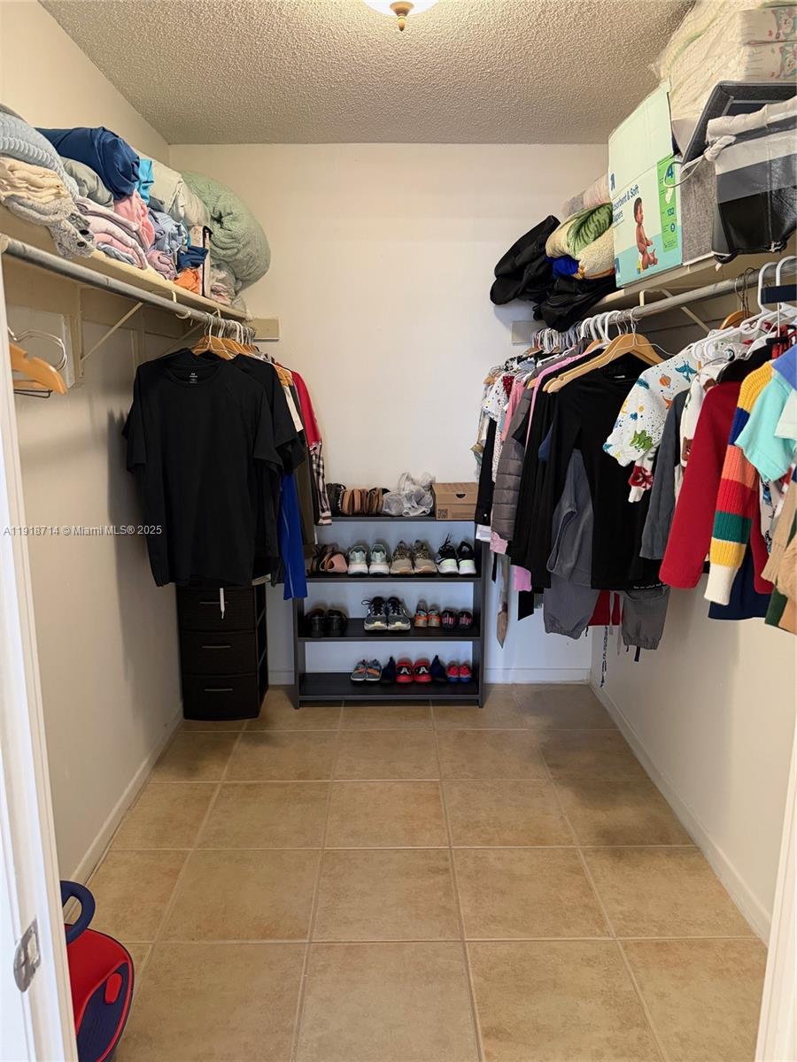 8411 Northwest 8th Street, Unit 405 Miami, FL 33126 - Photo 18 of 23 a view of walk in closet with clothes and shoes