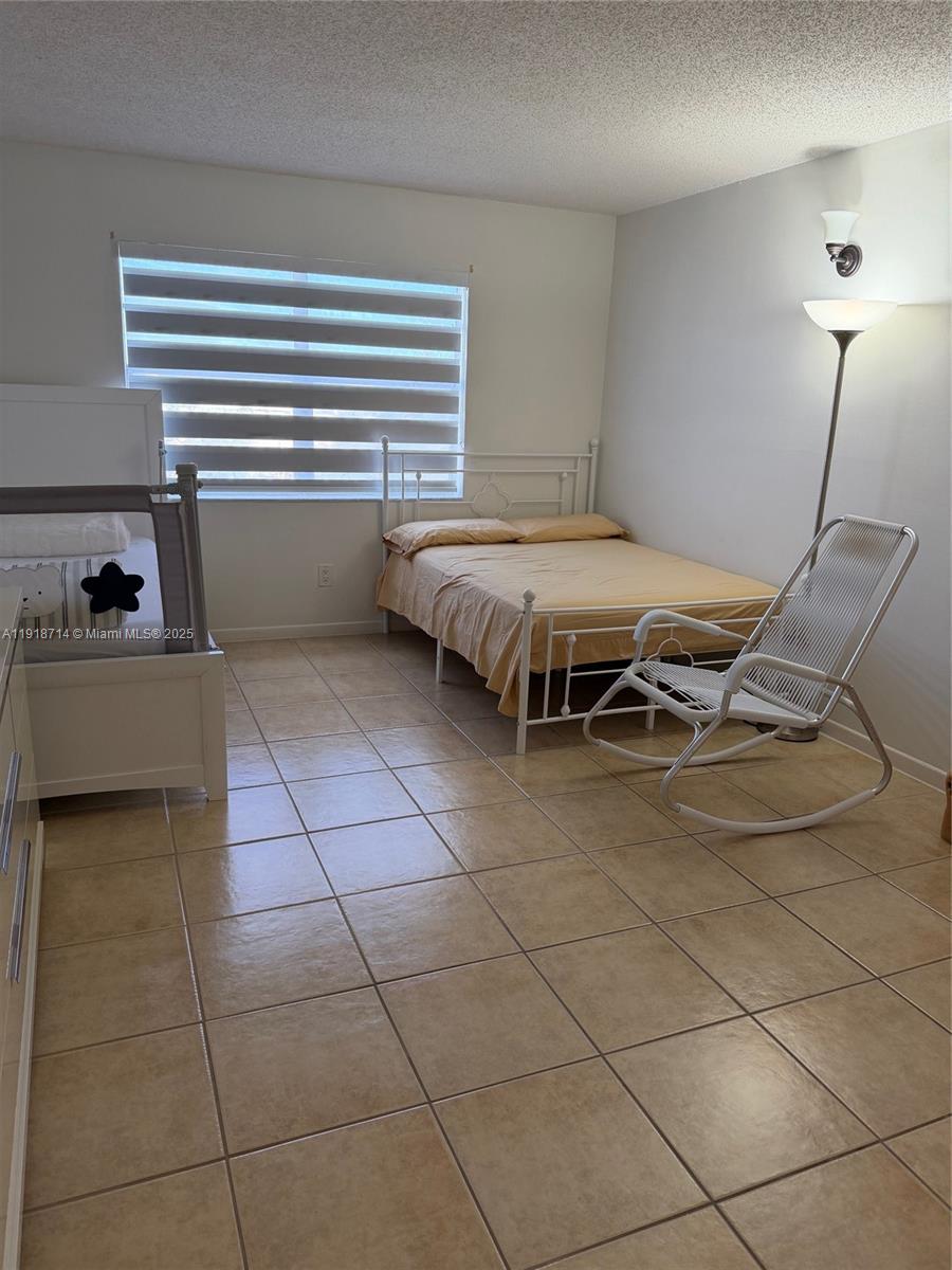 8411 Northwest 8th Street, Unit 405 Miami, FL 33126 - Photo 19 of 23 a bedroom with a bed and a table chair