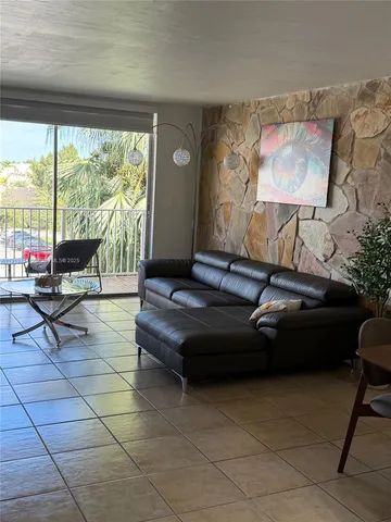 a living room with furniture and a floor to ceiling window