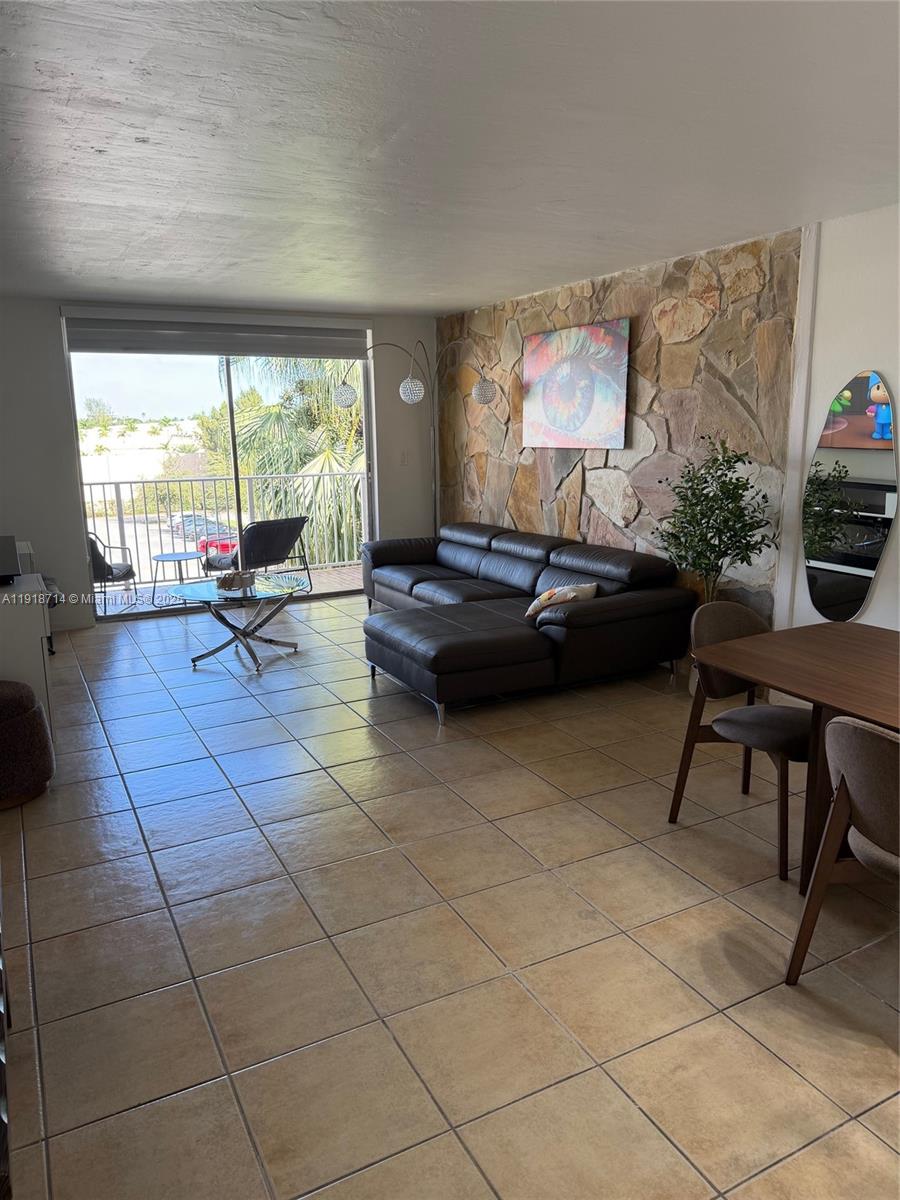 8411 Northwest 8th Street, Unit 405 Miami, FL 33126 - Photo 7 of 23 a living room with furniture and a large window