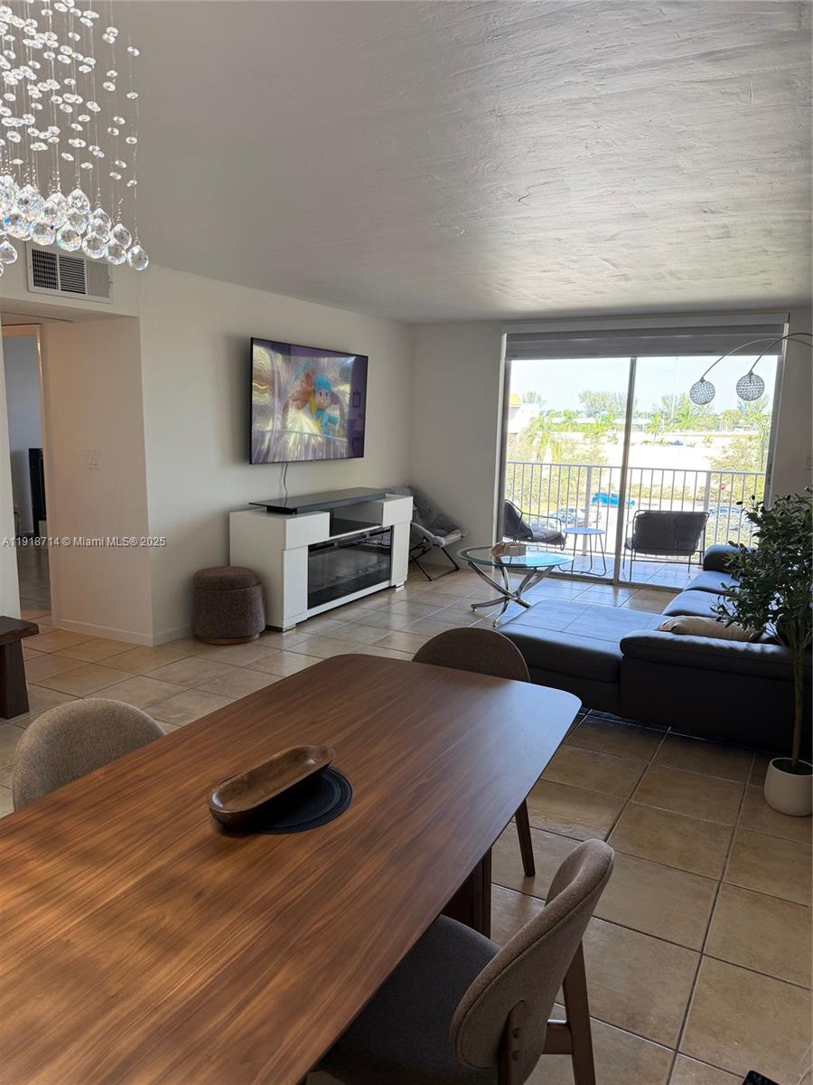 8411 Northwest 8th Street, Unit 405 Miami, FL 33126 - Photo 9 of 23 a living room with furniture and a flat screen tv
