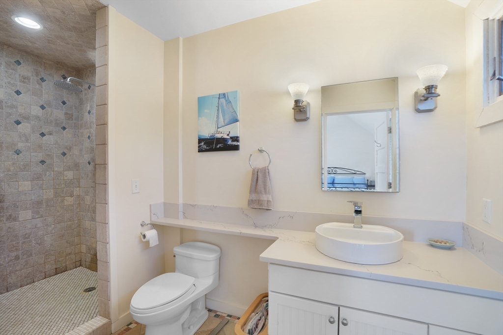 28 Crocker Drive Edgartown, MA 02539 - Photo 20 of 24 a bathroom with a sink toilet a mirror and shower