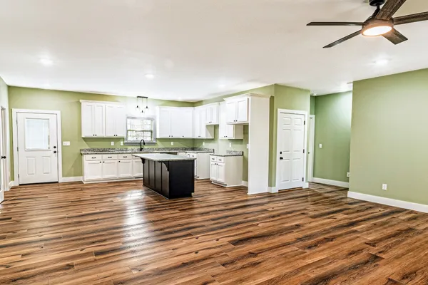 a large kitchen with kitchen island a sink stainless steel appliances and cabinets