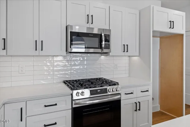 a kitchen with stainless steel appliances white cabinets and a stove