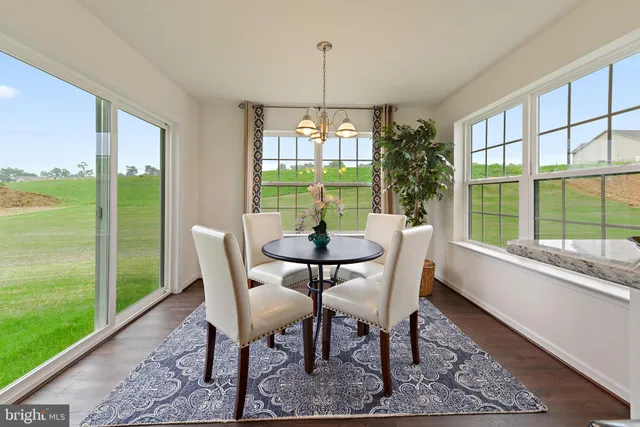 a dining room with furniture a chandelier and wooden floor