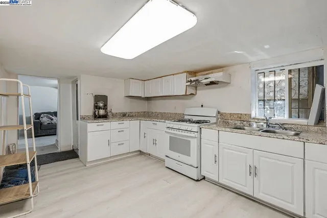a kitchen with granite countertop white cabinets and white appliances