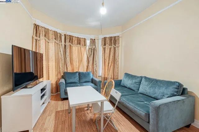 a living room with furniture a flat screen tv and a window