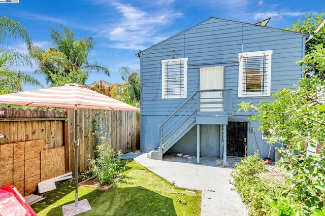 a view of a house with backyard and sitting area