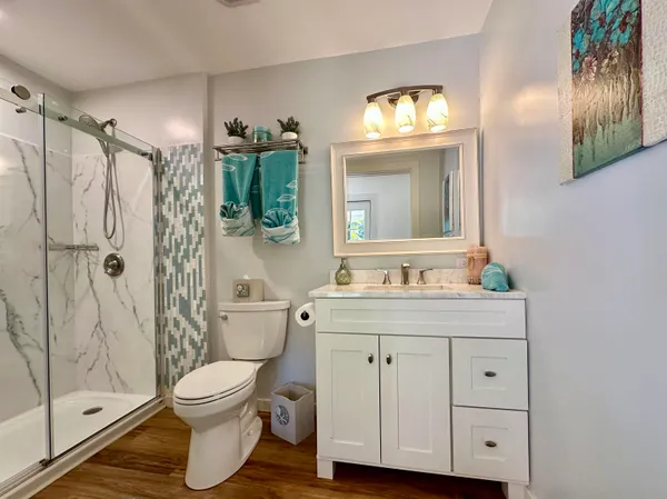 a bathroom with a granite countertop toilet a sink and a mirror