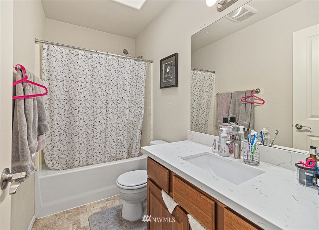 910 South 48th Street Renton, WA 98055 - Photo 18 of 30 a bathroom with a sink a toilet and shower curtain