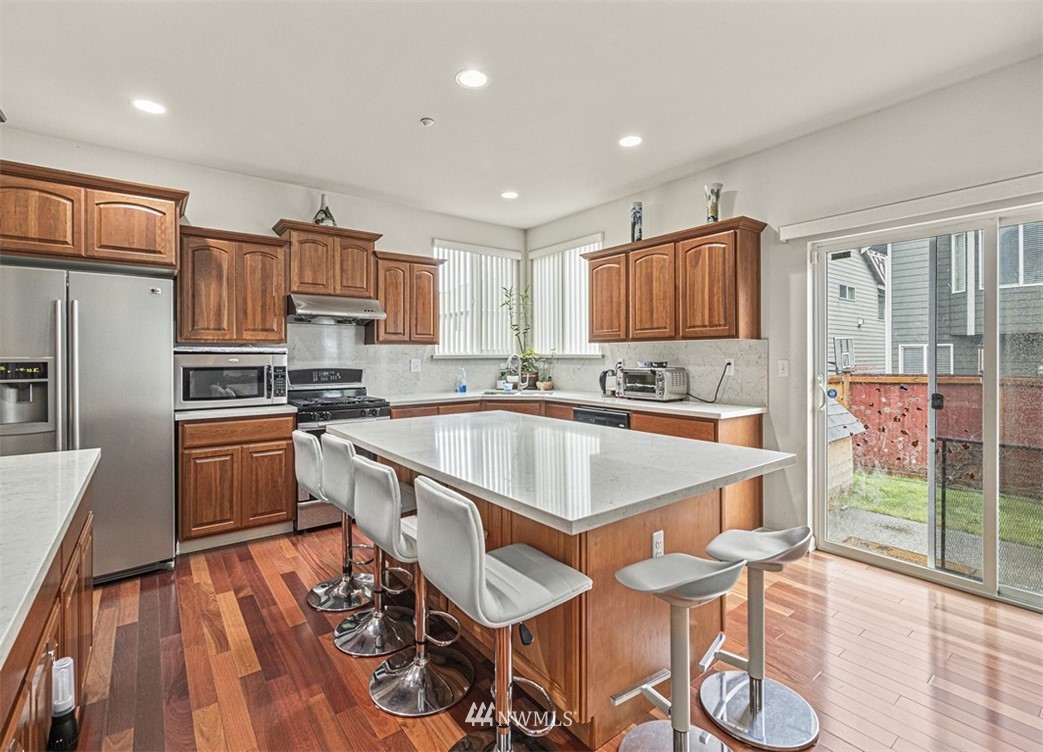 910 South 48th Street Renton, WA 98055 - Photo 9 of 30 a kitchen with stainless steel appliances granite countertop a sink a stove a refrigerator cabinets and dining table