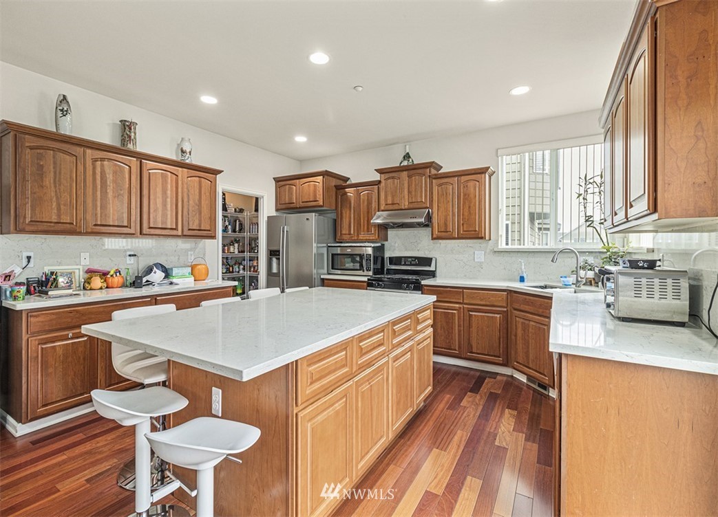 910 South 48th Street Renton, WA 98055 - Photo 10 of 30 a kitchen with stainless steel appliances granite countertop a stove a sink dishwasher and a refrigerator with wooden floor