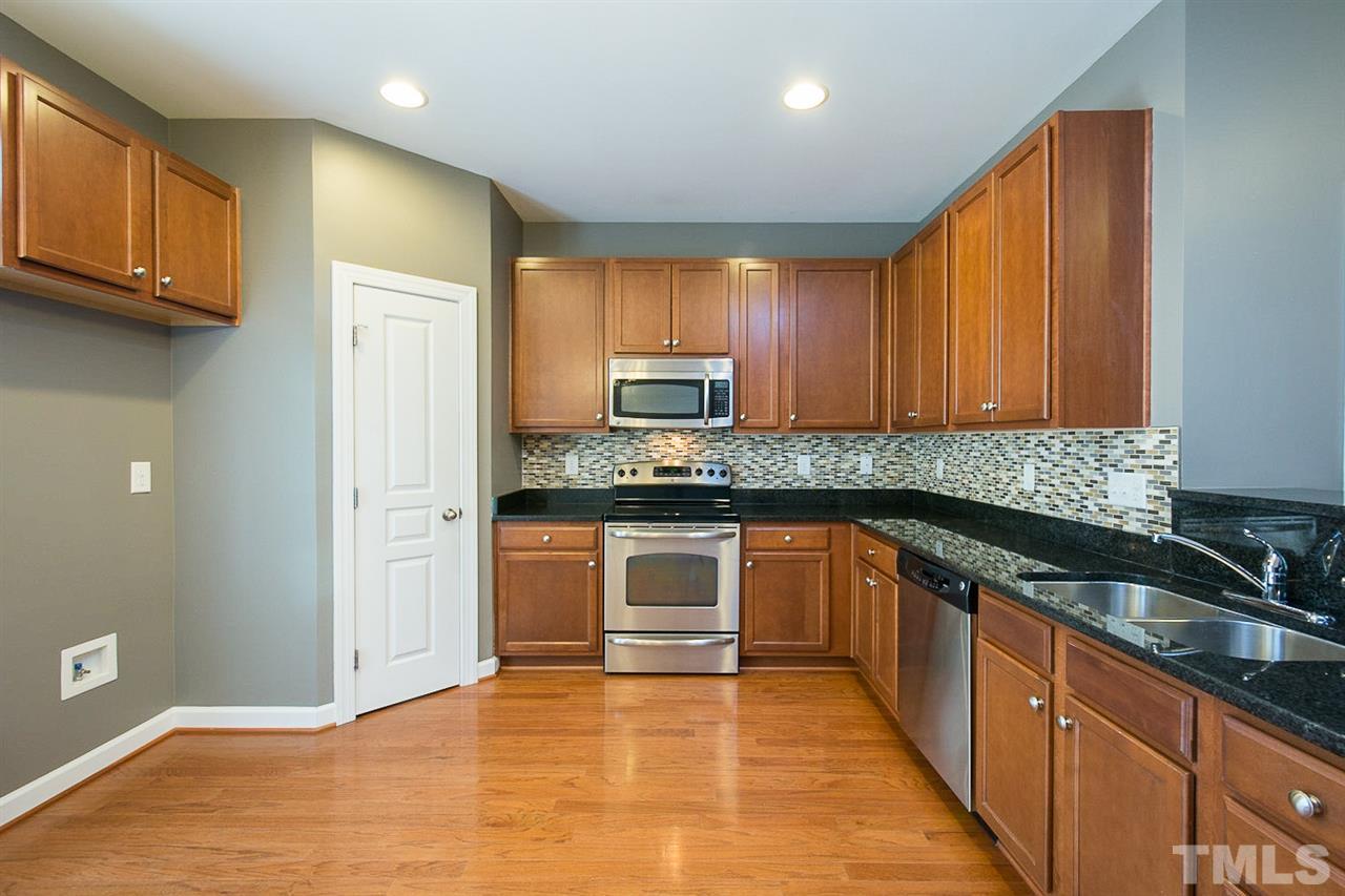 8016 Sycamore Hill Lane Raleigh, NC 27612 - Photo 3 of 19 a kitchen with stainless steel appliances granite countertop wooden cabinets a stove top oven a sink and dishwasher