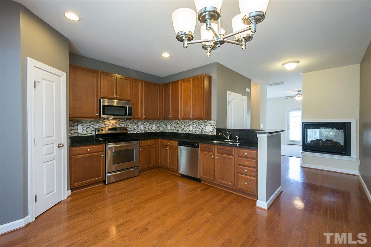 8016 Sycamore Hill Lane Raleigh, NC 27612 - Photo 7 of 19 a kitchen with stainless steel appliances granite countertop a refrigerator a stove top oven a sink and dishwasher with wooden floor