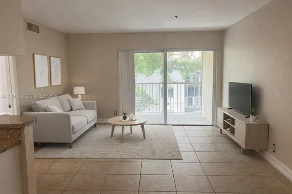 a living room with furniture a flat screen tv and a large window