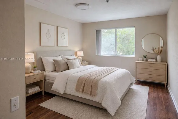 a bedroom with a bed and a dresser next to a window