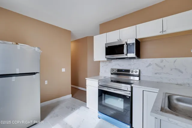 a kitchen with stainless steel appliances a stove microwave and refrigerator