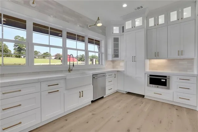 a kitchen with granite countertop a sink stainless steel appliances and cabinets