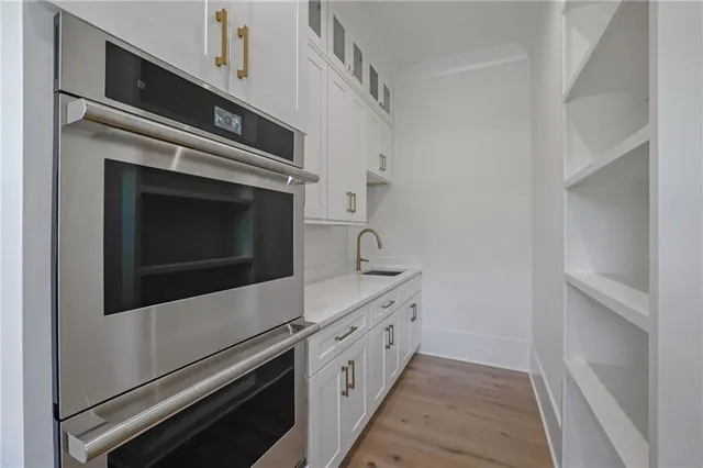 a view of a white house with many windows next to a yard