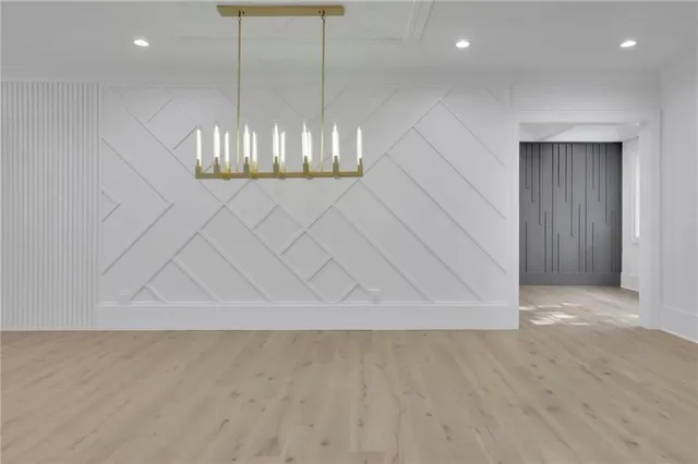 a view of a white house with many windows next to a yard